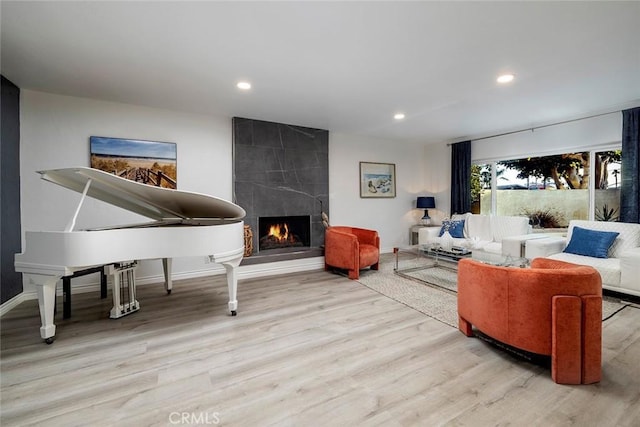 living room featuring light wood-type flooring and a fireplace