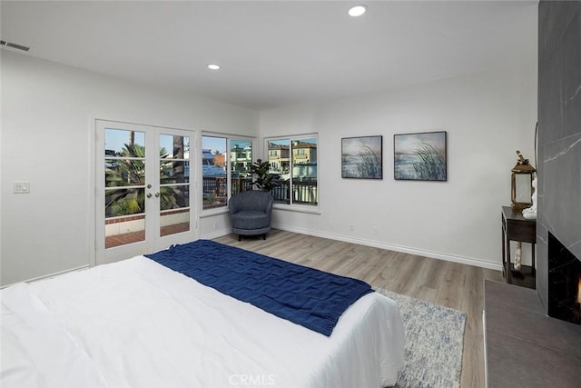 16592 Grimaud Ln, Huntington Beach, CA 92649 - bedroom with wood finished floors, recessed lighting, french doors, a large fireplace, and baseboards