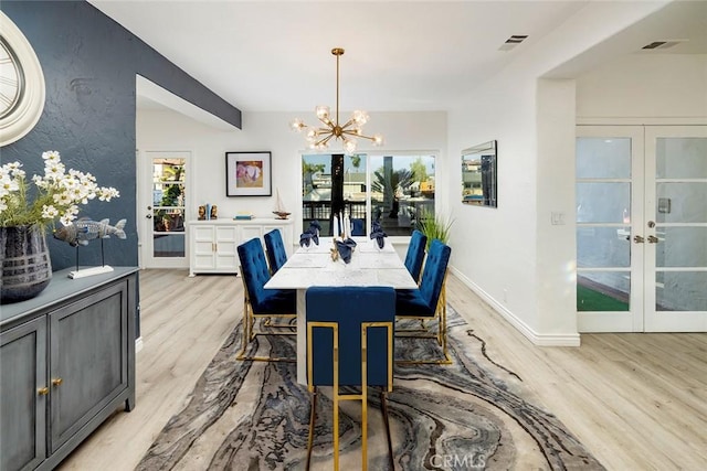 dining area featuring a chandelier, light wood-type flooring, and french doors