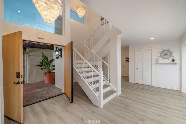 foyer entrance with wood-type flooring and a notable chandelier