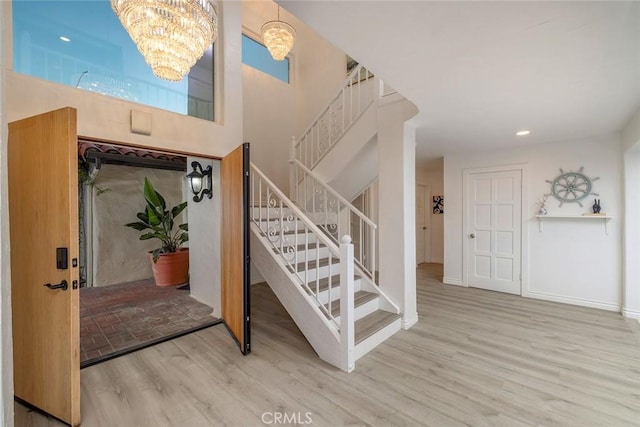 16592 Grimaud Ln, Huntington Beach, CA 92649 - foyer featuring a chandelier, stairs, wood finished floors, and baseboards