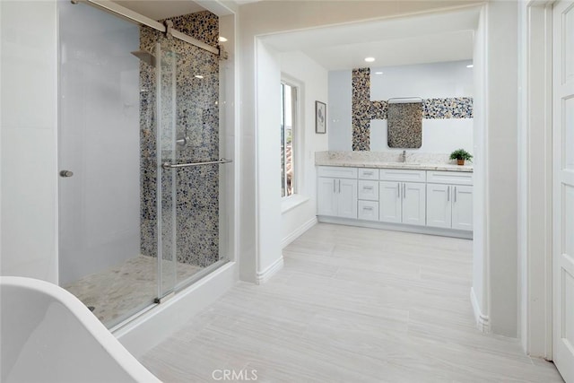16592 Grimaud Ln, Huntington Beach, CA 92649 - bathroom featuring a freestanding tub, vanity, a shower stall, and baseboards