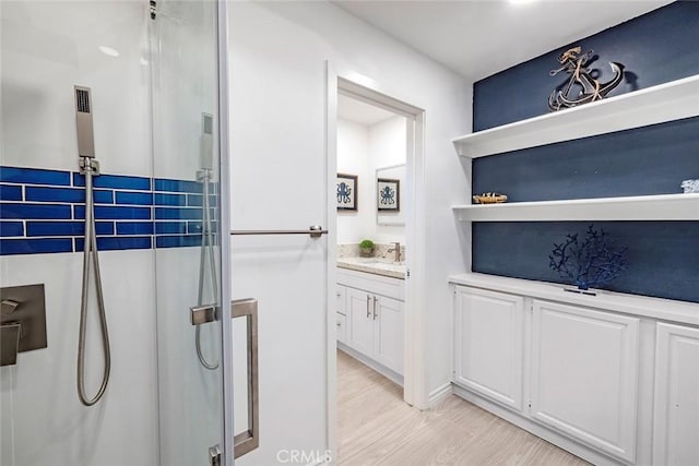 bathroom with vanity, an enclosed shower, and wood-type flooring