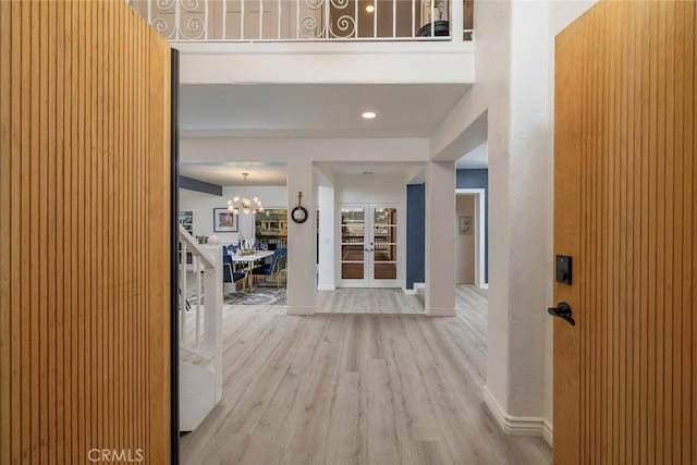 corridor with a notable chandelier and light hardwood / wood-style floors