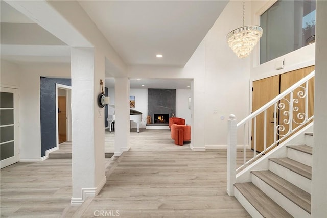 foyer with a chandelier, wood-type flooring, and a fireplace