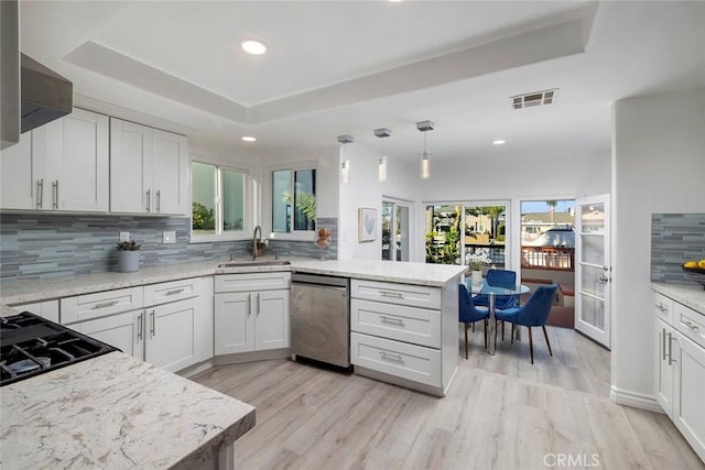 kitchen with white cabinets, dishwasher, kitchen peninsula, and a wealth of natural light