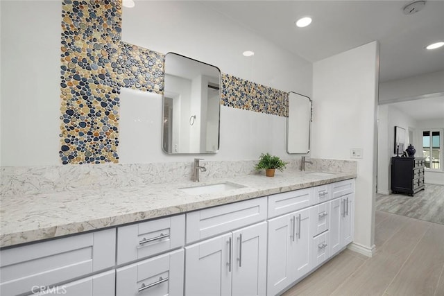 16592 Grimaud Ln, Huntington Beach, CA 92649 - bathroom featuring double vanity, wood finished floors, baseboards, and recessed lighting
