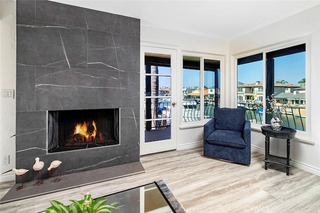 living room featuring a tile fireplace, wood-type flooring, and a water view