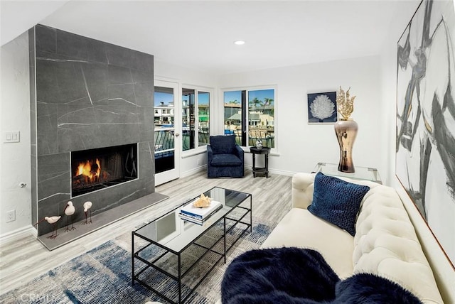 living room featuring light wood-type flooring and a tile fireplace