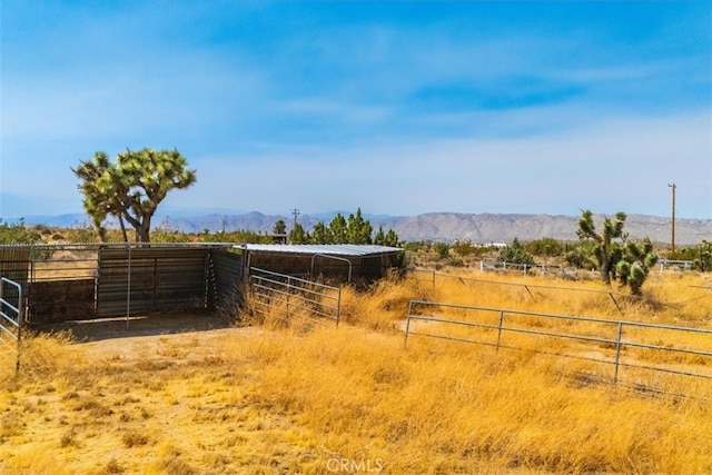 view of yard featuring a mountain view, a rural view, and an outdoor structure