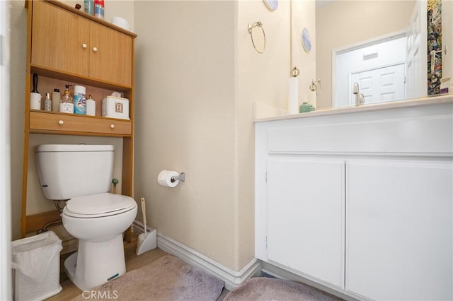 bathroom featuring vanity, toilet, and baseboards