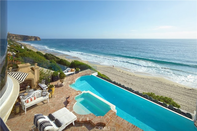 drone / aerial view featuring a water view and a beach view