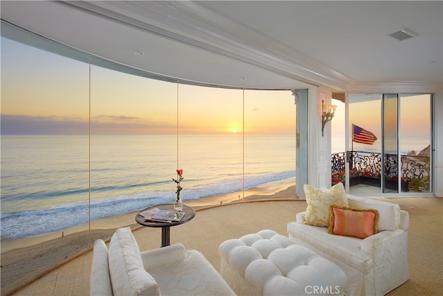 sitting room featuring a water view and carpet floors