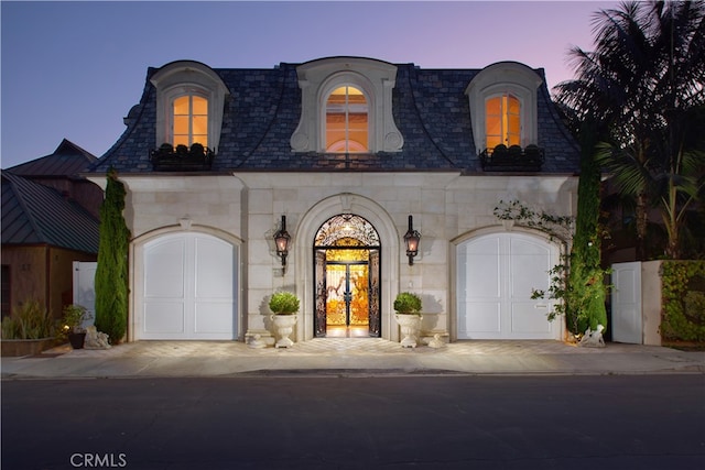 french provincial home featuring a garage