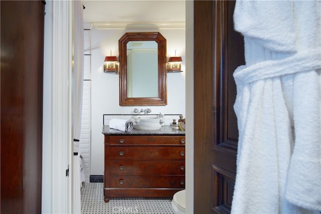 bathroom featuring vanity, ornamental molding, and toilet