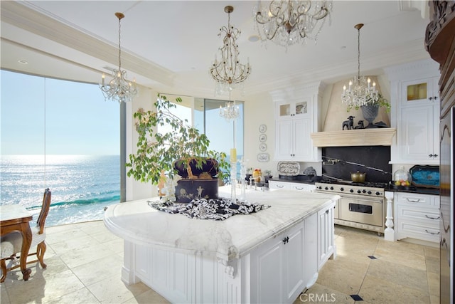 kitchen featuring white cabinetry, decorative backsplash, pendant lighting, and high end range