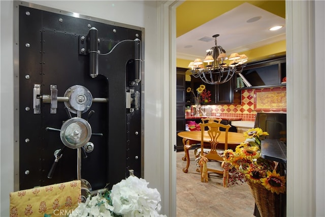 interior space featuring crown molding, a notable chandelier, and tasteful backsplash