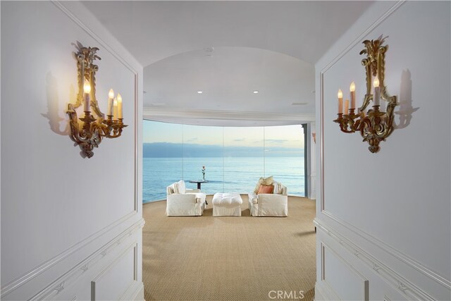 bedroom with crown molding, vaulted ceiling, a water view, and carpet flooring