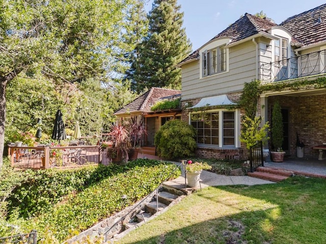 view of front of home featuring a front yard and a balcony