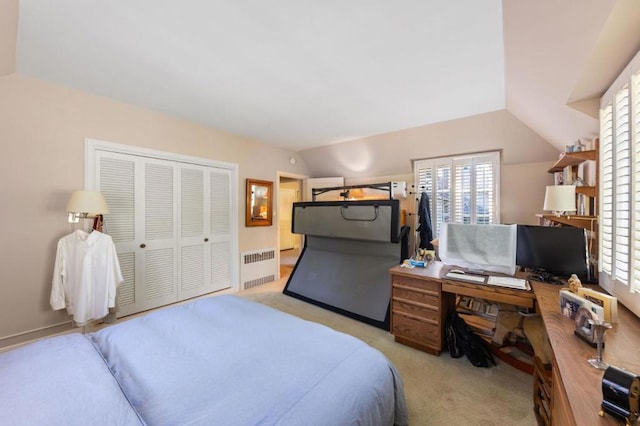 bedroom with multiple windows, a closet, radiator heating unit, and lofted ceiling