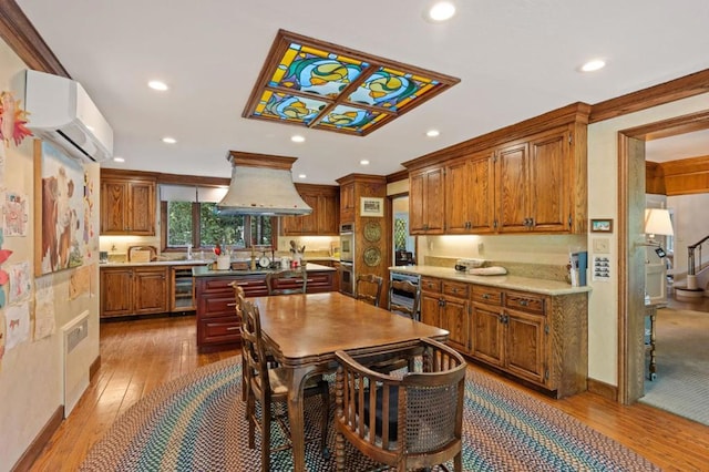 kitchen featuring stainless steel double oven, a wall mounted air conditioner, wine cooler, island exhaust hood, and light wood-type flooring