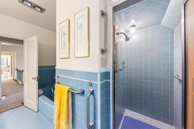 bathroom with tile patterned flooring, tile walls, and tiled shower