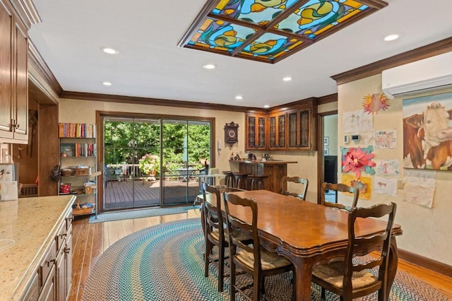 dining area with light wood-type flooring, ornamental molding, and a wall mounted AC