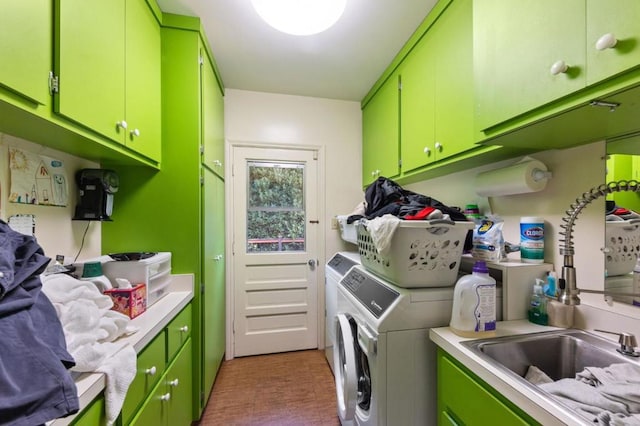 clothes washing area featuring cabinets, sink, and washing machine and dryer