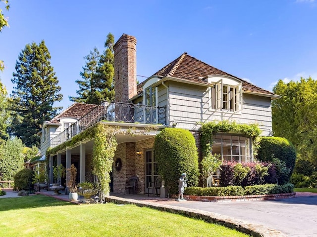 exterior space with a balcony and a front lawn