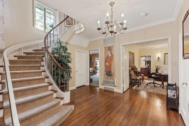 foyer entrance featuring ornamental molding, dark hardwood / wood-style floors, and a notable chandelier