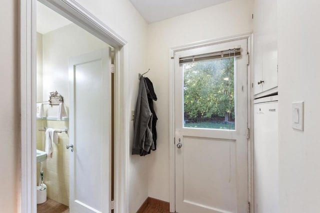 doorway featuring wood-type flooring and tile walls