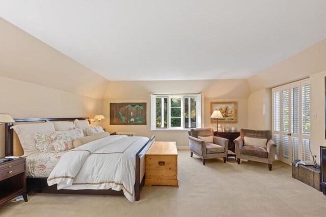 carpeted bedroom featuring vaulted ceiling and multiple windows