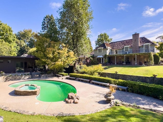 view of pool featuring a lawn, a patio area, and an in ground hot tub