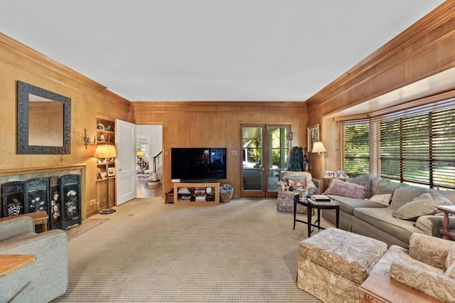 carpeted living room featuring wooden walls, french doors, and ornamental molding