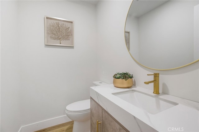 bathroom with vanity, hardwood / wood-style floors, and toilet