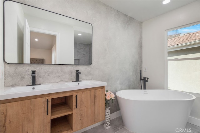 bathroom featuring a bathtub, tile patterned flooring, and vanity