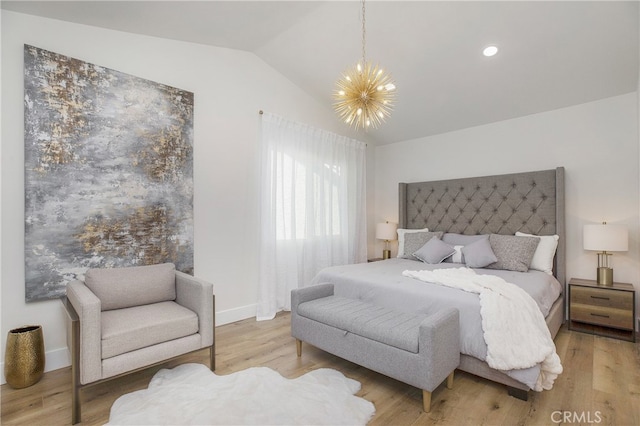 bedroom featuring an inviting chandelier, lofted ceiling, and hardwood / wood-style flooring