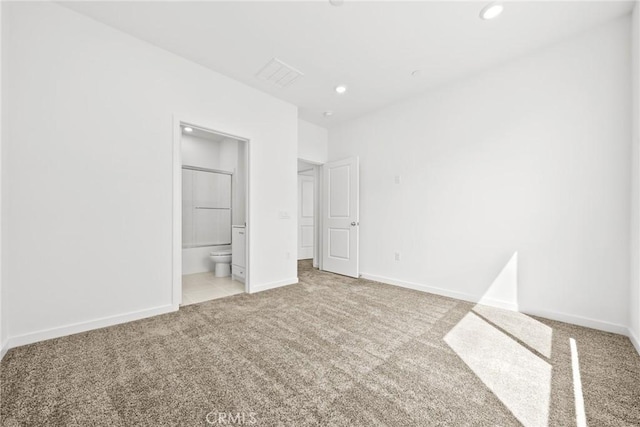 unfurnished bedroom with light carpet and connected bathroom