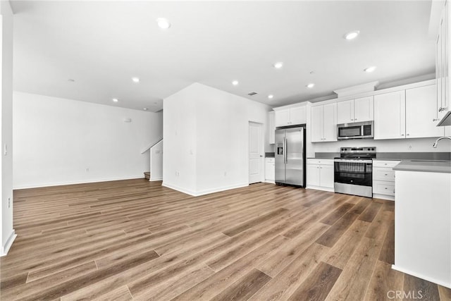 kitchen featuring sink, white cabinets, stainless steel appliances, and light hardwood / wood-style floors