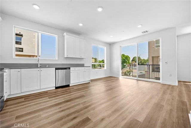 kitchen with dishwasher, light wood-type flooring, white cabinets, and sink