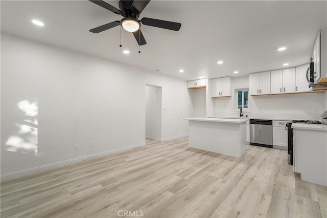 kitchen featuring light wood-type flooring, white cabinetry, and stainless steel dishwasher