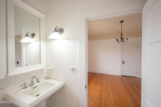 bathroom featuring hardwood / wood-style flooring, an inviting chandelier, and sink