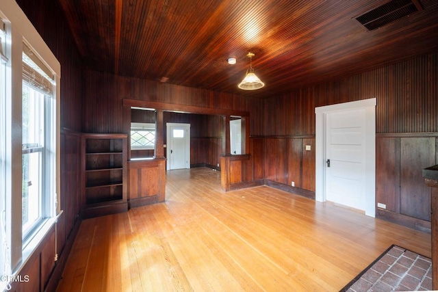 unfurnished room with light hardwood / wood-style floors, wood ceiling, and wood walls