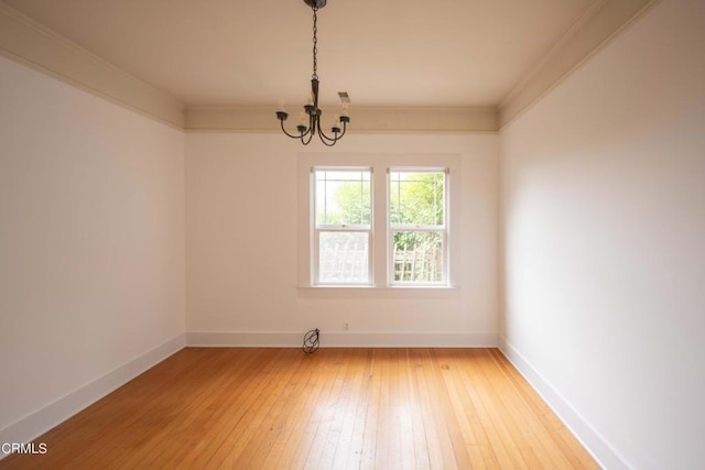 unfurnished room with crown molding, a notable chandelier, and hardwood / wood-style flooring