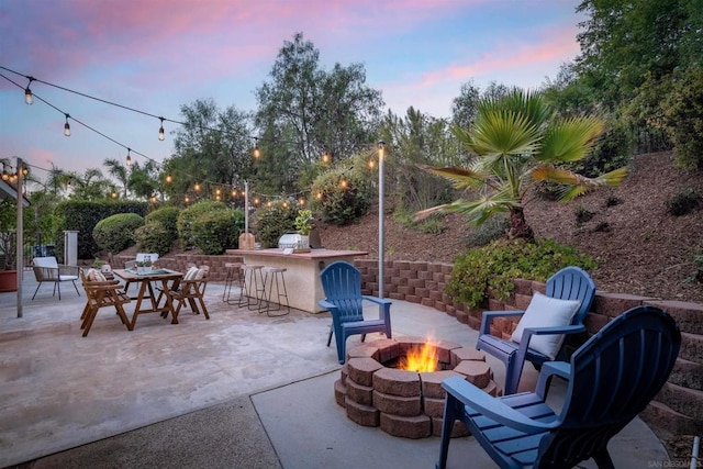 patio terrace at dusk with an outdoor bar and an outdoor fire pit