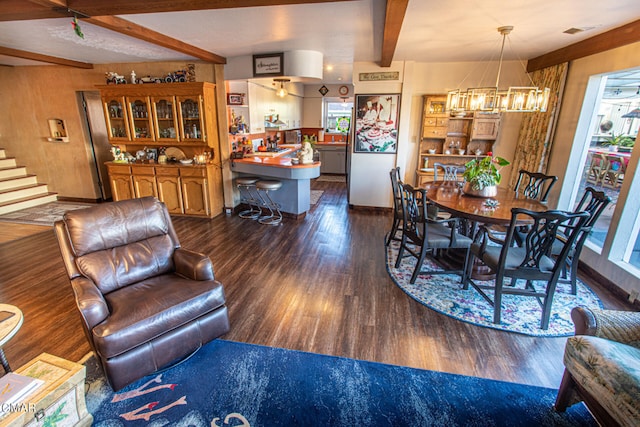 living room featuring a notable chandelier, beam ceiling, and dark hardwood / wood-style flooring