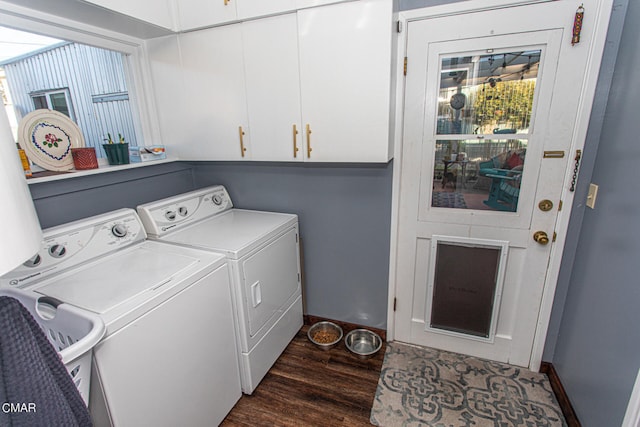 clothes washing area with separate washer and dryer, dark wood-type flooring, and cabinets