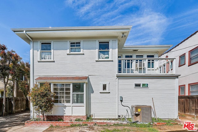 back of property with central AC unit and a balcony