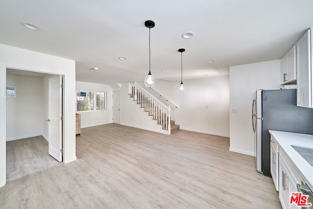 kitchen with pendant lighting, white cabinetry, and light hardwood / wood-style flooring