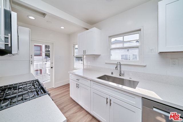 kitchen with dishwasher, white cabinets, a healthy amount of sunlight, and sink